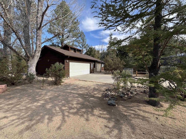 view of side of home featuring a garage and driveway