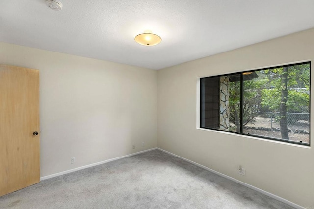 unfurnished room featuring carpet and baseboards