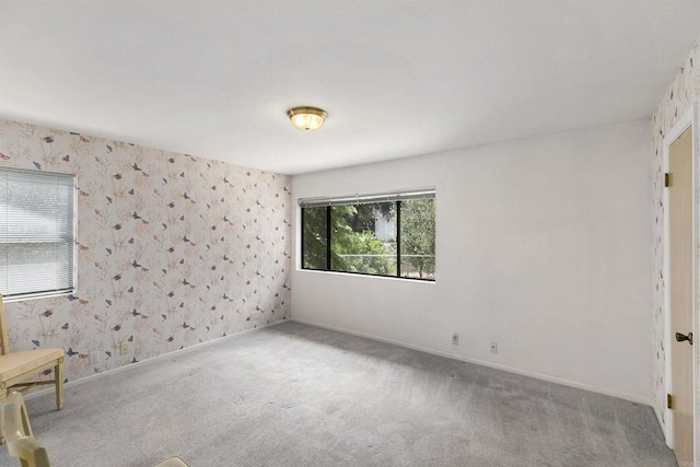 unfurnished room with wallpapered walls, baseboards, and carpet floors