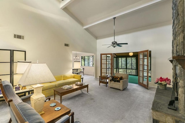 carpeted living room with beamed ceiling, a fireplace, visible vents, and french doors