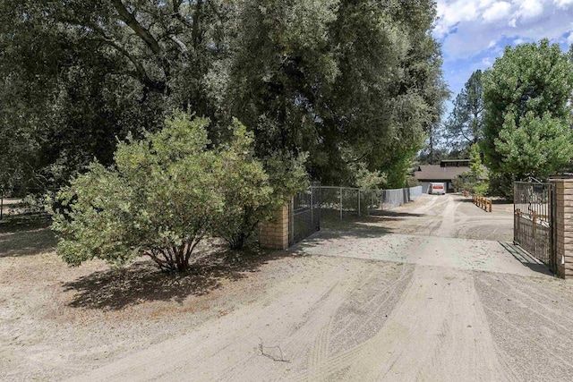 view of street featuring a gated entry, driveway, and a gate