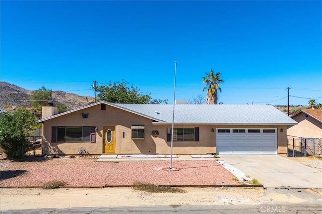 6818 El Sol Ave Unit 29, Palms, CA 92277 - single story home featuring a garage, concrete driveway, stucco siding, fence, and a chimney