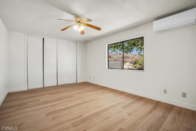 6818 El Sol Ave Unit 29, Palms, CA 92277 - unfurnished bedroom featuring a wall mounted air conditioner, light wood finished floors, baseboards, and ceiling fan