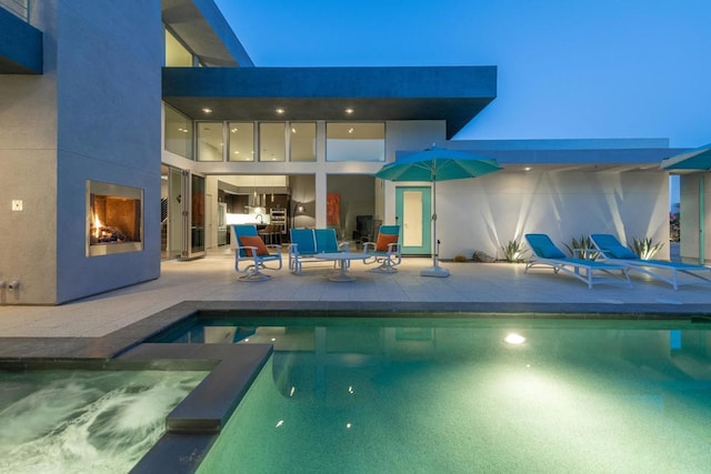 view of swimming pool featuring a large fireplace and a patio area