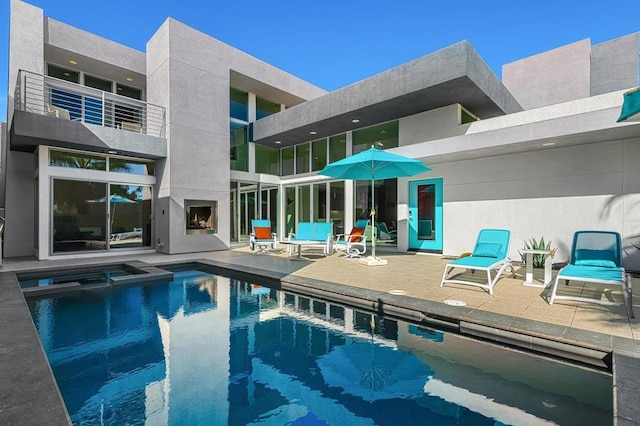 view of swimming pool with exterior fireplace and a patio