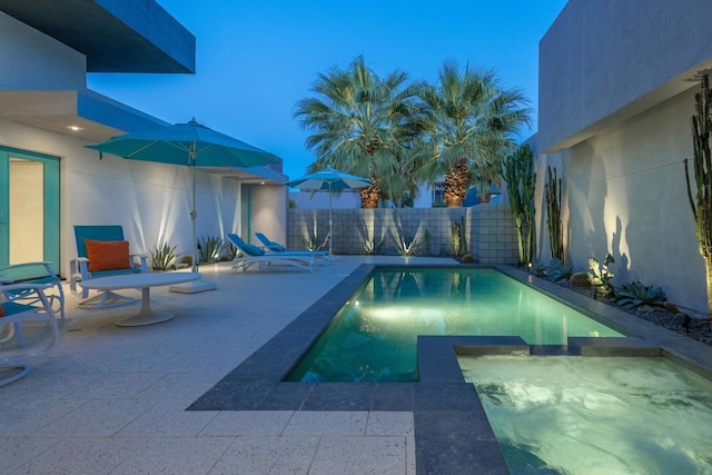 pool at dusk with a patio