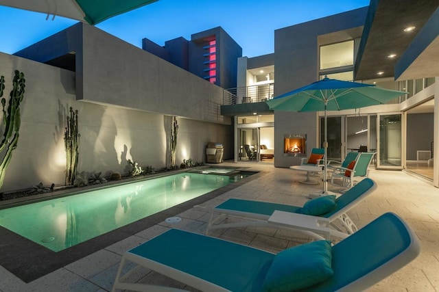 pool at dusk featuring a patio area