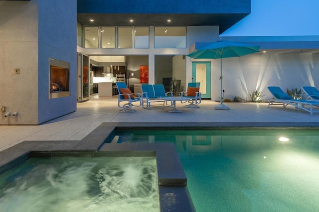 view of pool featuring a fireplace and a patio