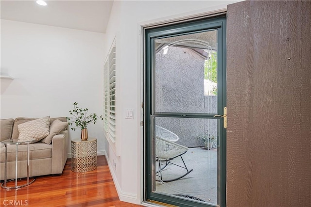 doorway to outside with wood finished floors and baseboards