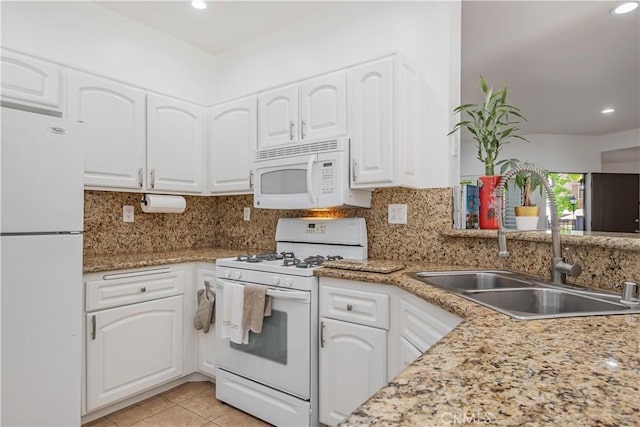 kitchen featuring white appliances, white cabinetry, and backsplash