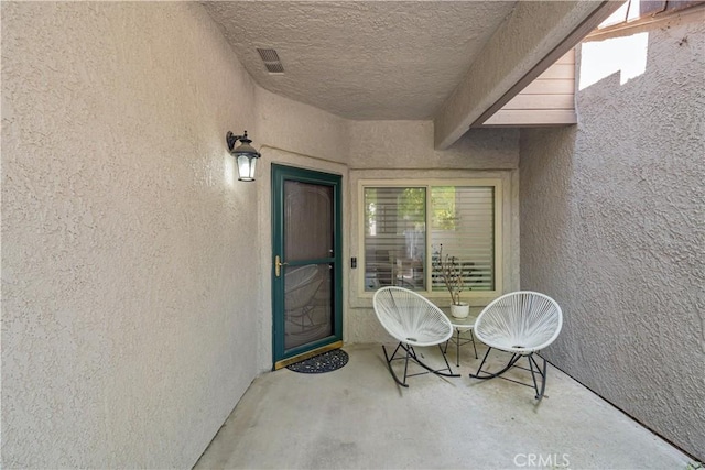 property entrance with visible vents and stucco siding