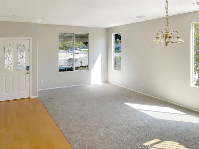 foyer entrance featuring carpet floors and an inviting chandelier