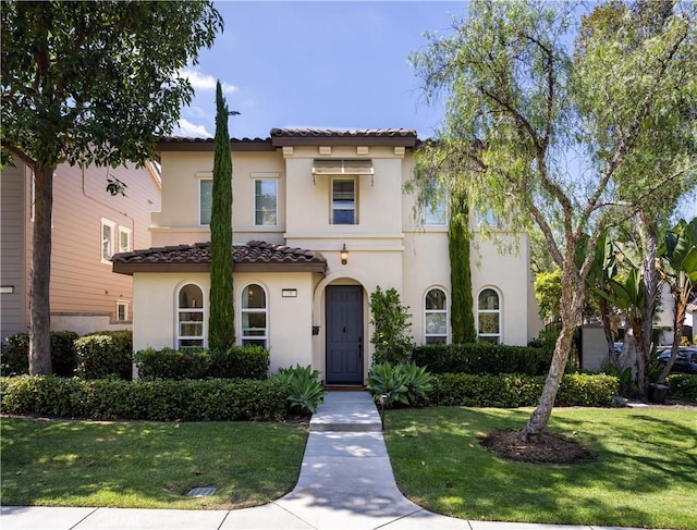 mediterranean / spanish house featuring a front yard