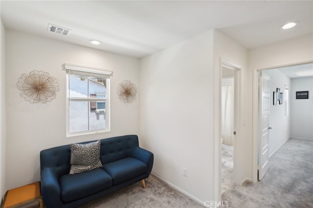 living area featuring light carpet