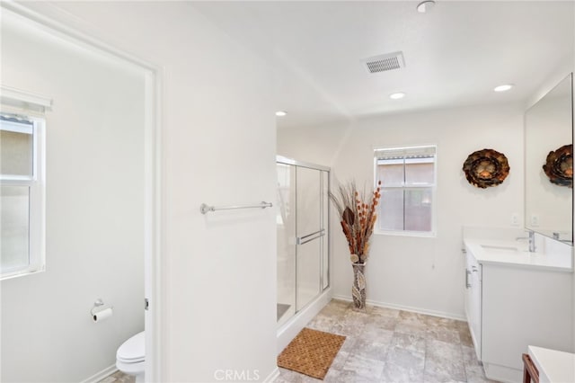 bathroom featuring a shower with door, vanity, and toilet