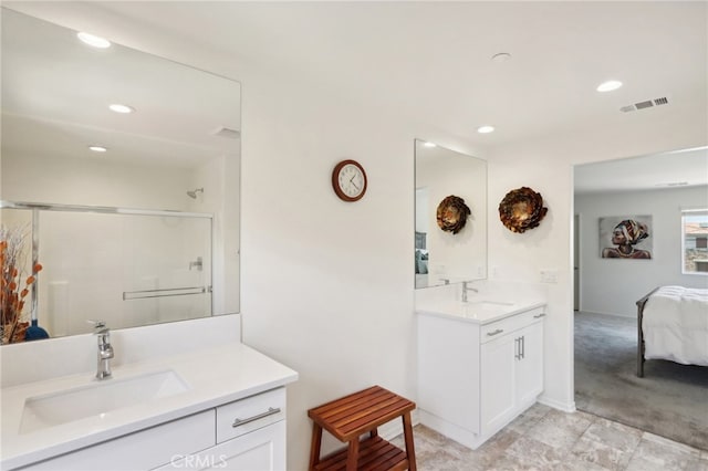 bathroom featuring a shower with door and vanity