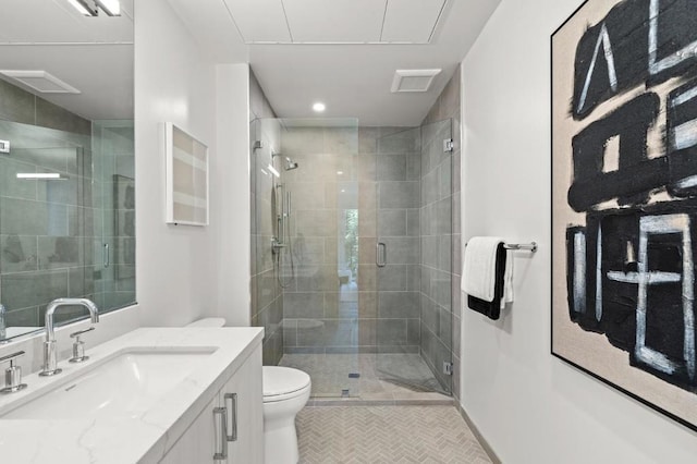 bathroom featuring toilet, vanity, tile patterned floors, and a shower with shower door