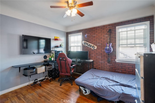 bedroom with ceiling fan, hardwood / wood-style floors, and brick wall