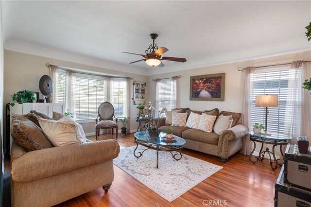 living room with ornamental molding, hardwood / wood-style floors, and ceiling fan