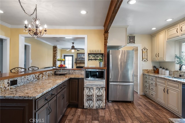 kitchen featuring light stone countertops, cream cabinets, dark hardwood / wood-style floors, and appliances with stainless steel finishes