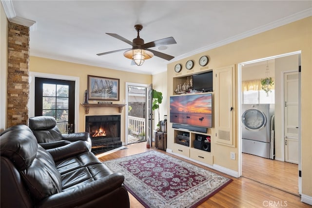 living room with crown molding, ceiling fan, hardwood / wood-style floors, and washer / clothes dryer