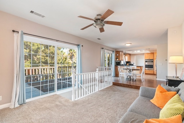 carpeted living room featuring ceiling fan