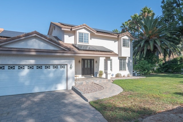 view of property featuring a front lawn, solar panels, and a garage