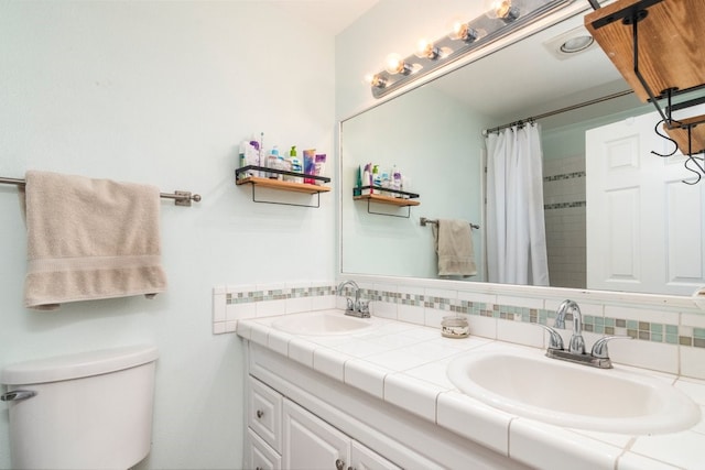 bathroom with vanity, toilet, a shower with shower curtain, and tasteful backsplash