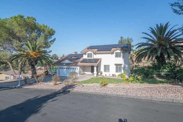 view of front of house featuring solar panels and a garage