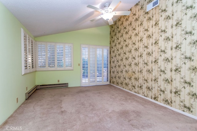 spare room with ceiling fan, vaulted ceiling, a textured ceiling, and carpet flooring