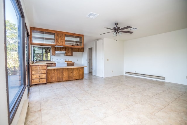 kitchen featuring ceiling fan, sink, kitchen peninsula, baseboard heating, and electric range