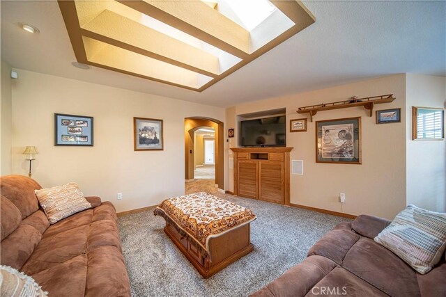 carpeted living room with a skylight