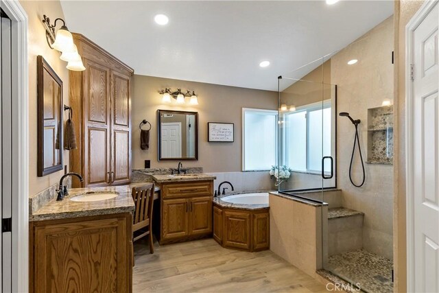 bathroom with vanity, shower with separate bathtub, and hardwood / wood-style floors