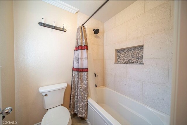 bathroom featuring crown molding, shower / bath combo with shower curtain, and toilet