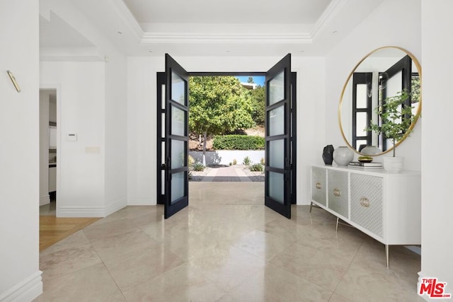 entrance foyer with a raised ceiling and ornamental molding