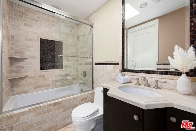 full bathroom with enclosed tub / shower combo, vanity, tile patterned flooring, and toilet