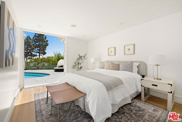 bedroom featuring wood-type flooring and access to exterior