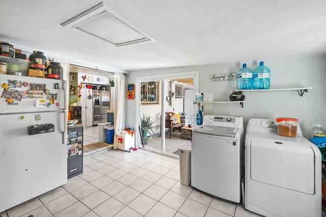 washroom featuring washer and clothes dryer and light tile patterned flooring