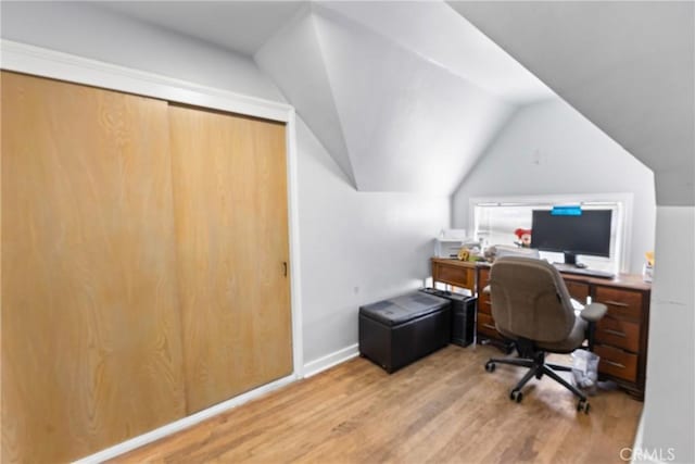 office space featuring vaulted ceiling, wood finished floors, and baseboards