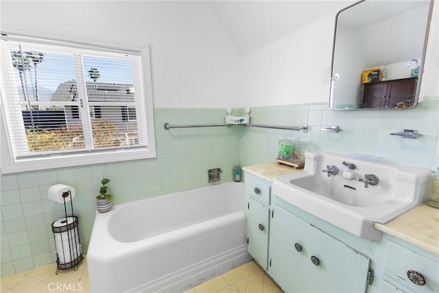 bathroom with tile walls, plenty of natural light, and vaulted ceiling