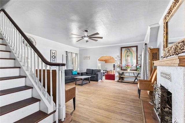41695 Mayberry Ave, Hemet, CA 92544 - living room featuring a ceiling fan, a fireplace, stairs, arched walkways, and wood finished floors