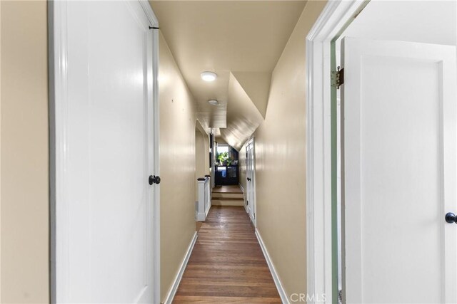 corridor featuring dark wood-style floors and baseboards