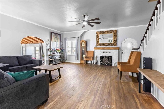 41695 Mayberry Ave, Hemet, CA 92544 - living room featuring a ceiling fan, a fireplace, wood finished floors, ornamental molding, and arched walkways
