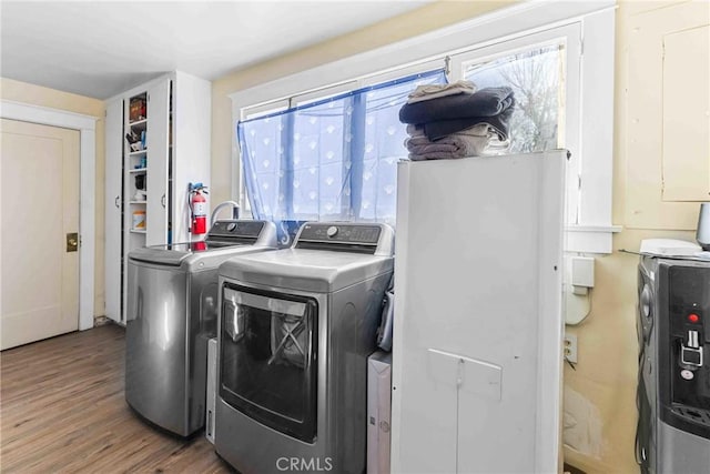 clothes washing area with separate washer and dryer and hardwood / wood-style floors