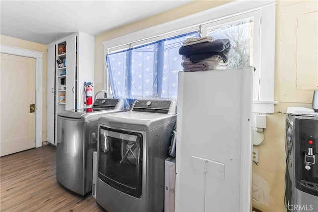 laundry room featuring wood finished floors, laundry area, and washer and clothes dryer