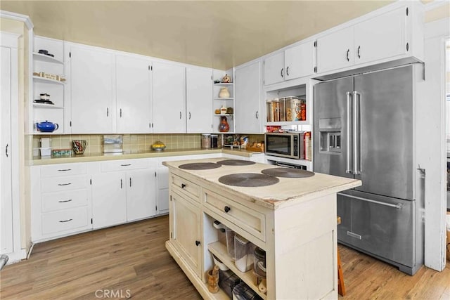 kitchen with light wood-style flooring, open shelves, white cabinetry, stainless steel appliances, and light countertops