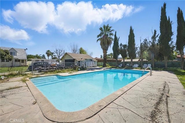 pool with a patio area and fence