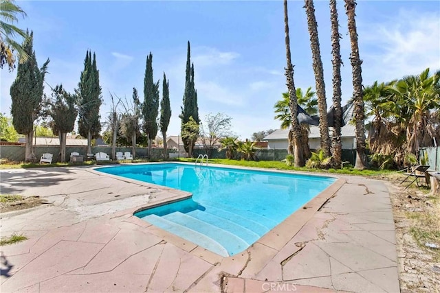 view of pool with a fenced in pool, fence, and a patio area