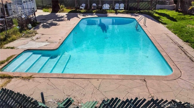 view of swimming pool with a patio area, a fenced in pool, and fence