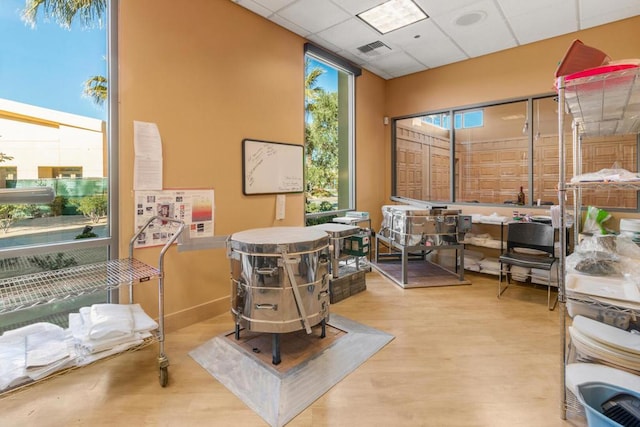 office area with a paneled ceiling and hardwood / wood-style flooring